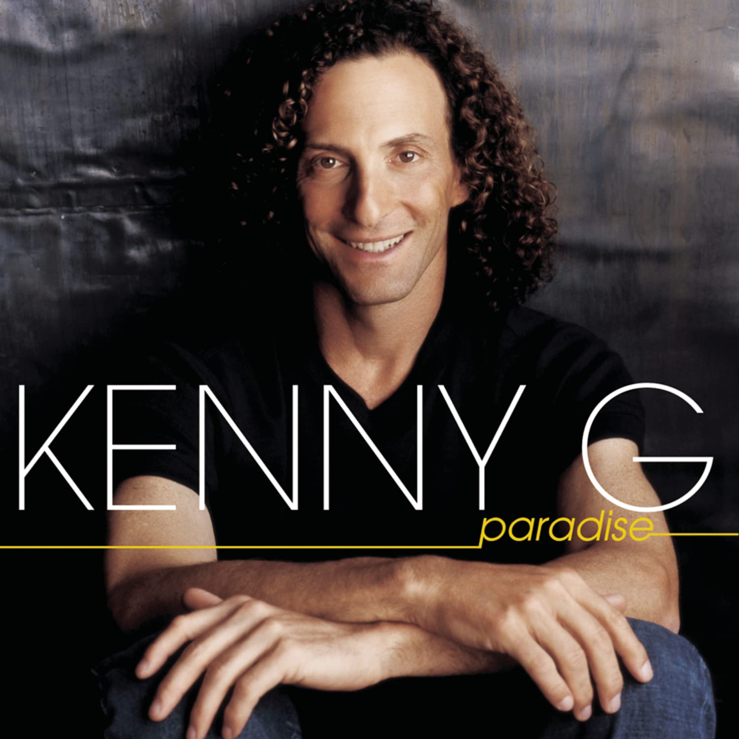 Album cover featuring a person with 'Kenny G' and 'paradise' text on a dark background